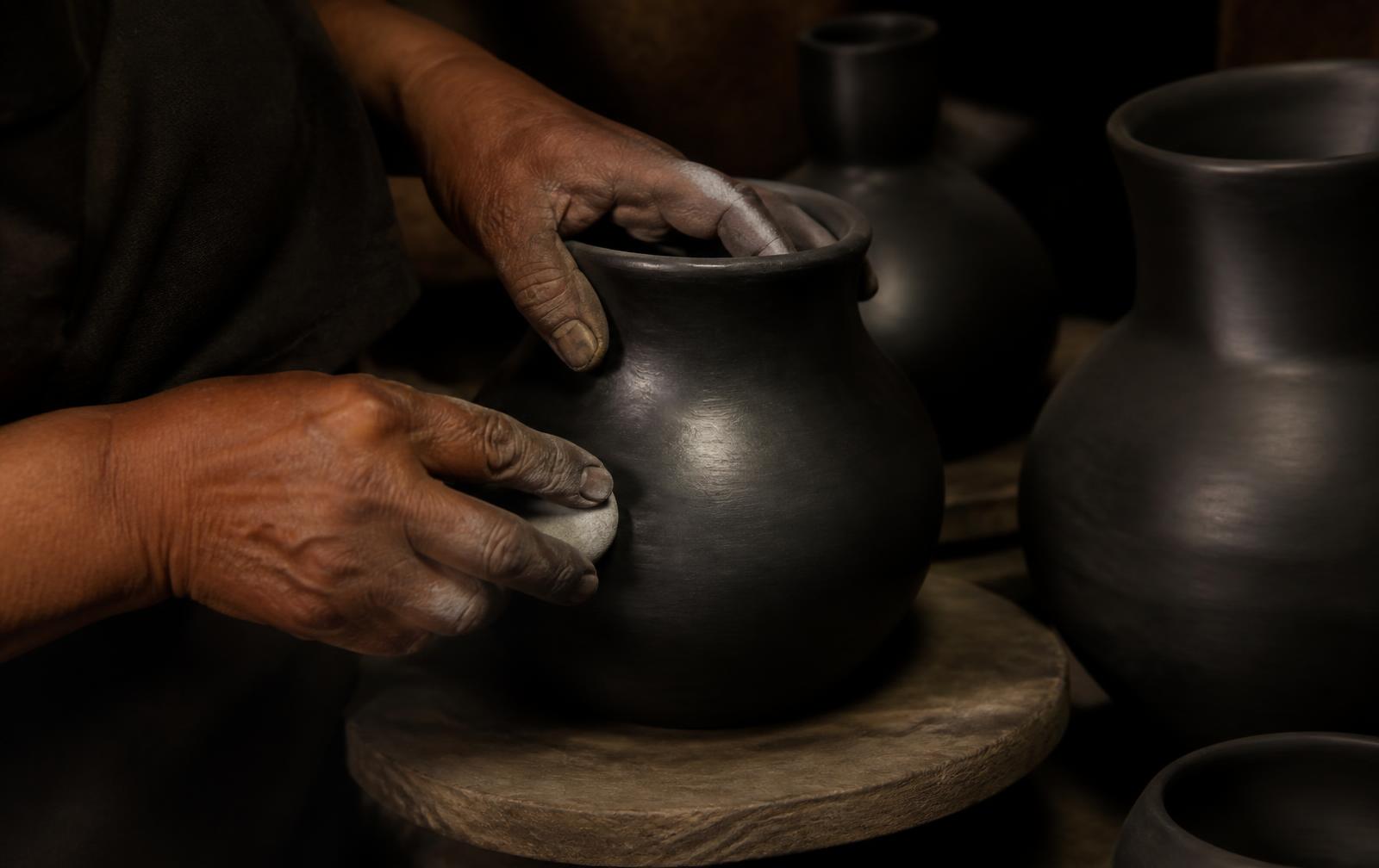 Alfarero de San Bartolo Coyotepec bruñendo con piedra de cuarzo una pieza aún cruda.